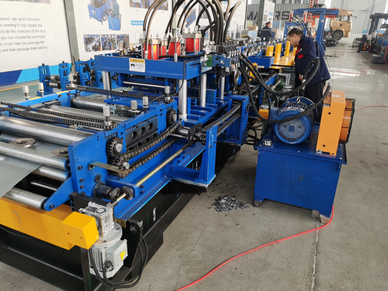 The PLC adjustment CZ purlin making machine shown in an industrial environment, featuring its main structural frame, drive systems, and control interfaces, with a technician present near the operational section.